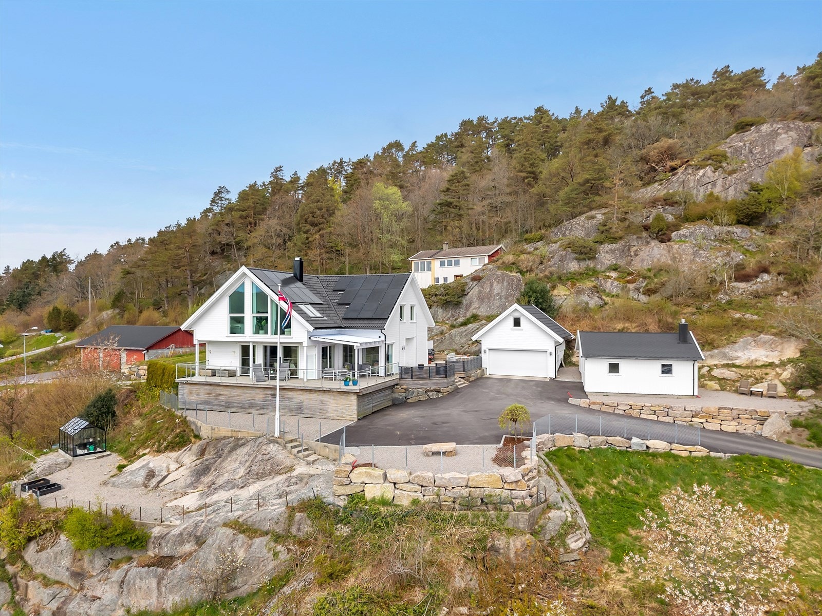 Eiendommen ligger høyt og fritt med asfaltert gårdsplass og dobbelgarasje. Galleribilde