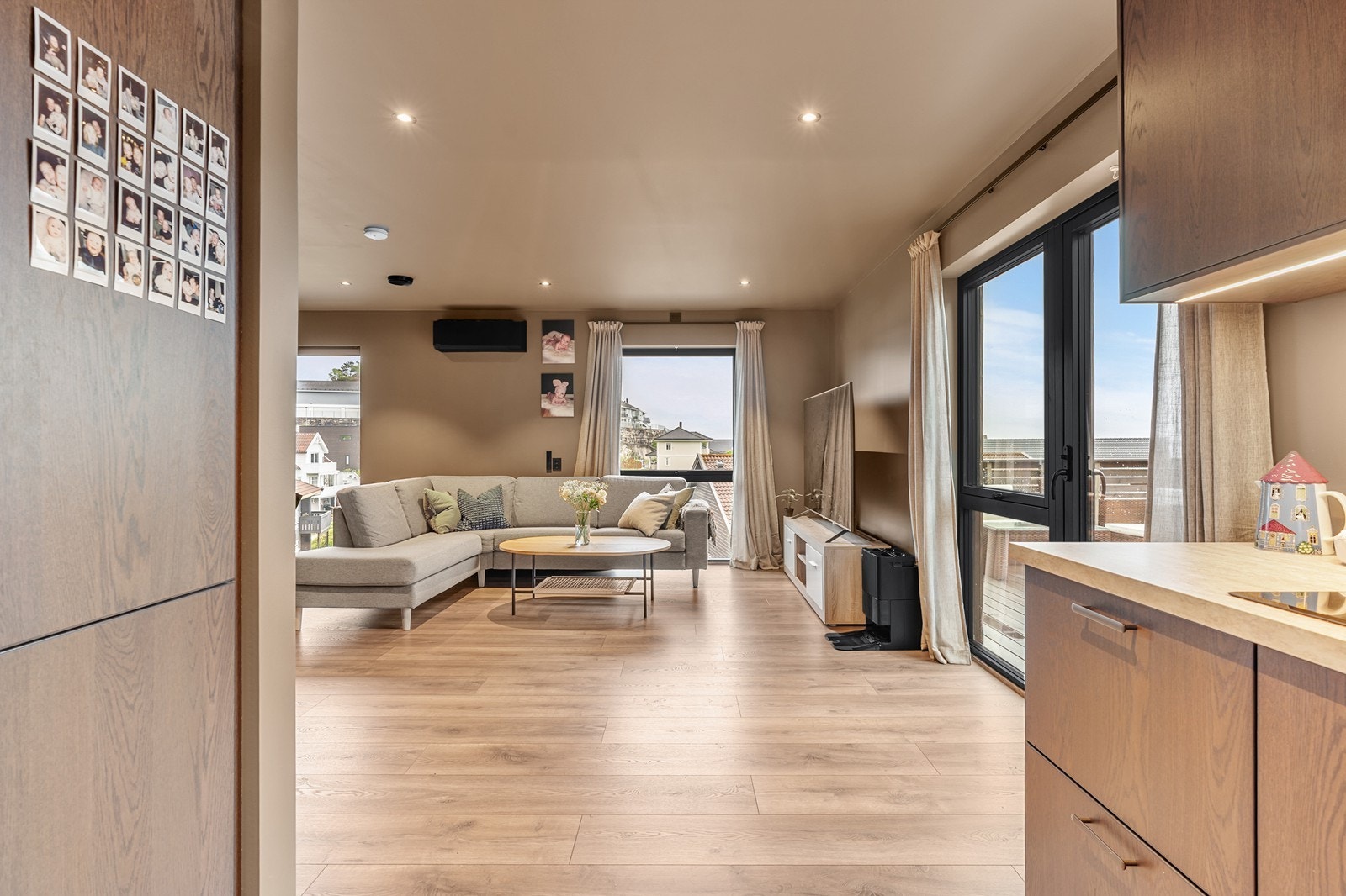 Den gjennomførte fargepaletten med varme beige toner på både vegger og himling skaper en rolig og elegant atmosfære, mens sorte detaljer tilfører et moderne uttrykk. Galleribilde