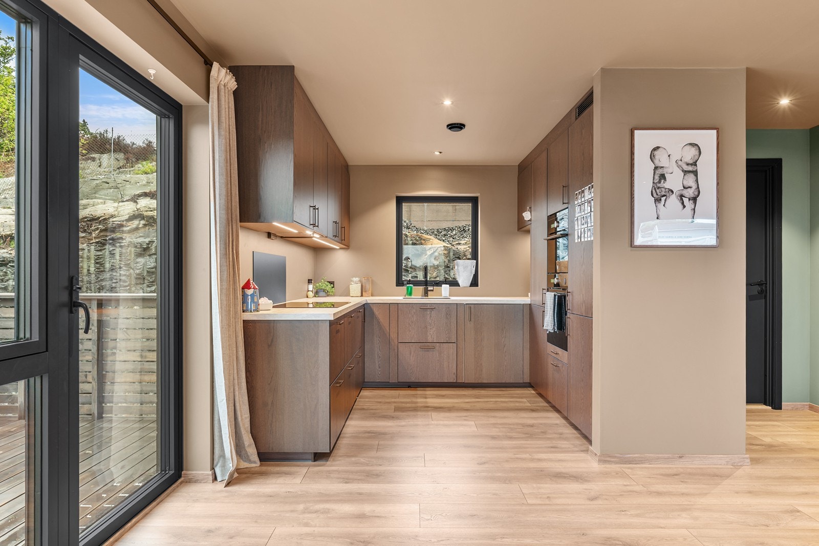 Kjøkkenet har en moderne innredning med glatte fronter og laminatbenkeplate. Galleribilde
