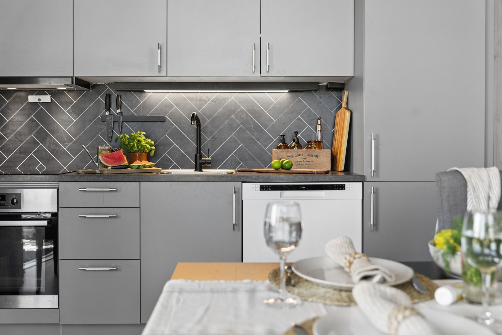 Delikat kitchenboard mellom benkeplate og overskap. Galleribilde