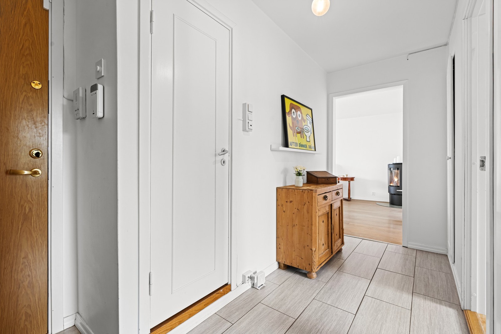 Vel inne blir man ønsket velkommen inn i en romslig entre med lyse veggflater, fliser på gulv og dørcalling. Galleribilde