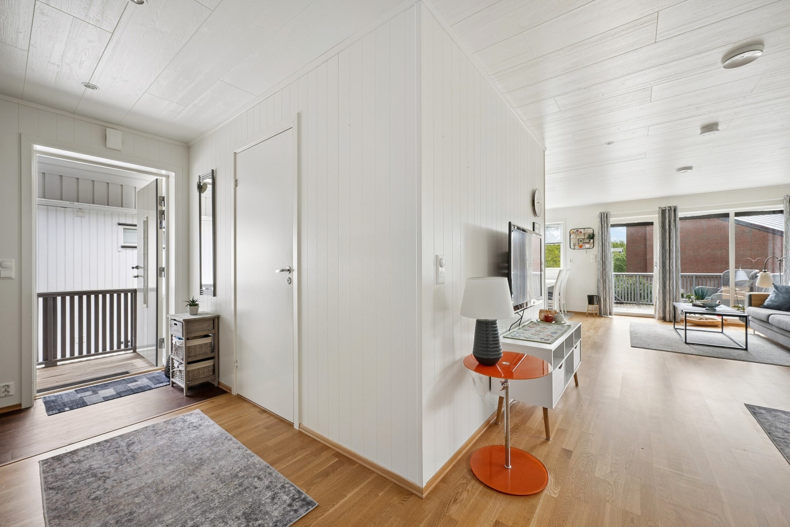 Fra entréen, med carport rett utenfor, kommer du inn i boligens åpne og sosiale sone. Galleribilde