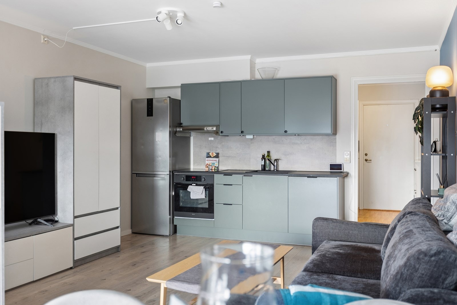 Funksjonelt kjøkken i åpen løsning mot stuen, som gjør det sosialt og enkelt å kombinere matlaging og samvær. Tidløse overflater gir et helhetlig uttrykk. Galleribilde