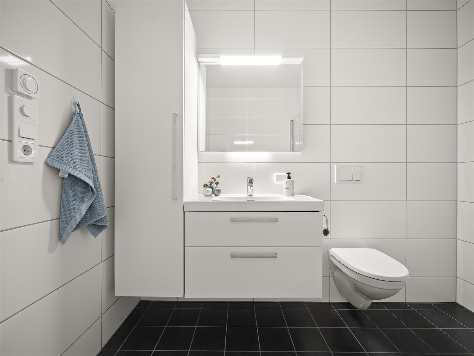 Badet er utstyrt med servantskap og høyskap for god oppbevaring, flislagte vegger og behagelig vannbåren gulvvarme som gir høy komfort i hverdagen. Galleribilde