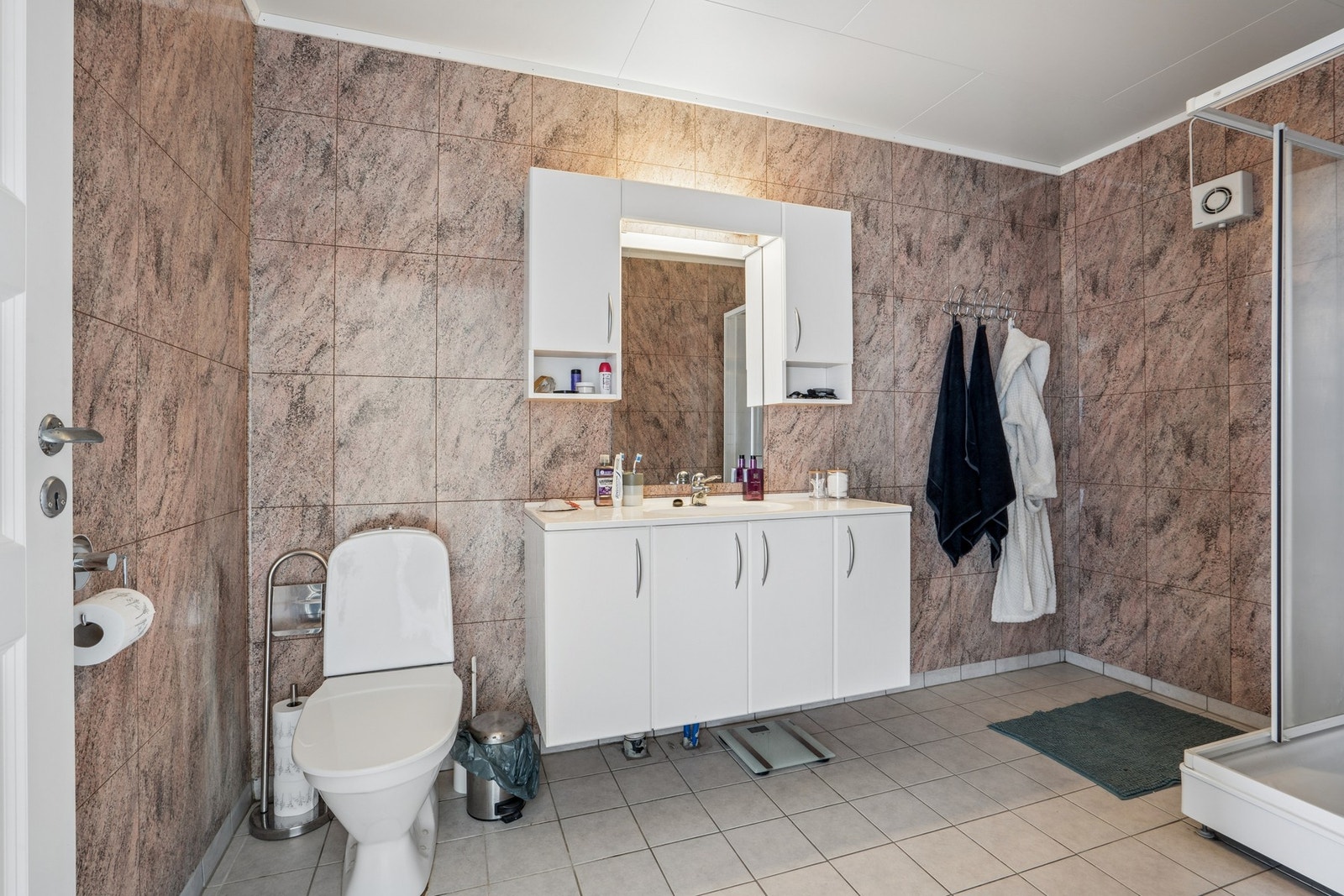 Badet i sokkelleiligheten har flislagt gulv med varmekabler og mekanisk avtrekk. Galleribilde