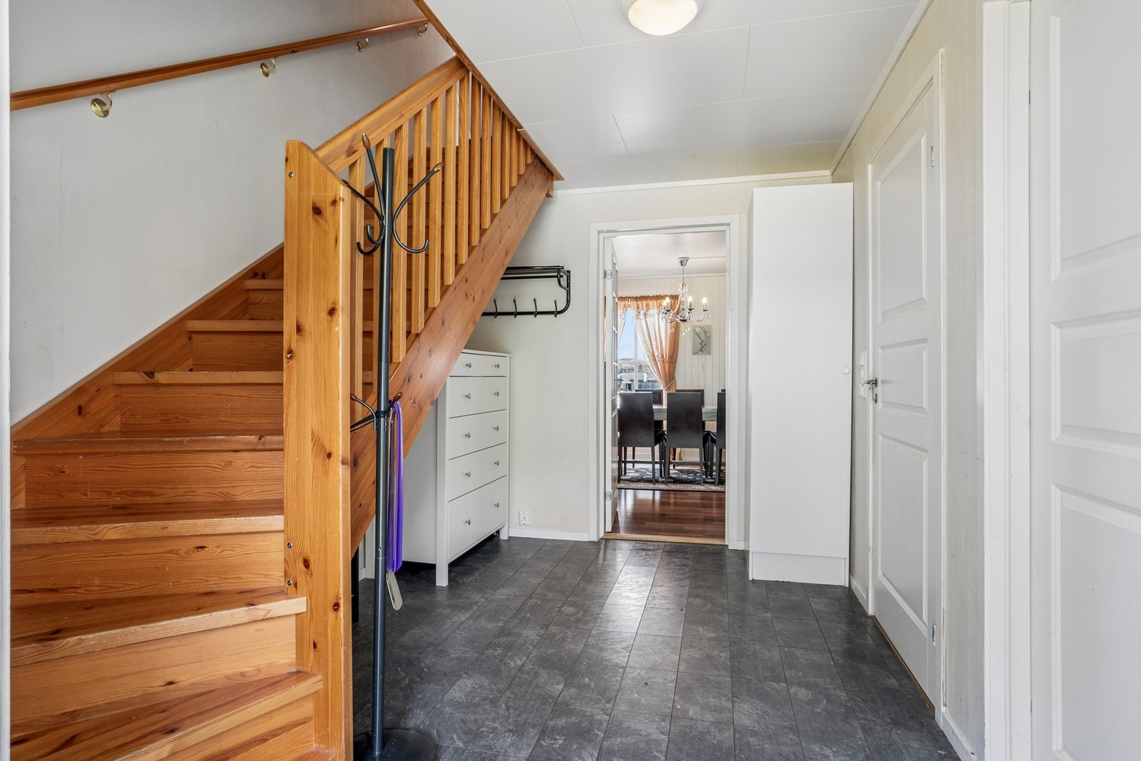 Entré i hovedetasjen med lakkert, tett tretrapp som fører opp til loftsetasjen. Galleribilde