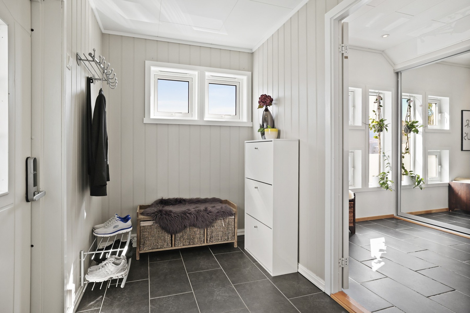 Innbydende entré med flislagt gulv og stor skyvedørsgarderobe. Galleribilde