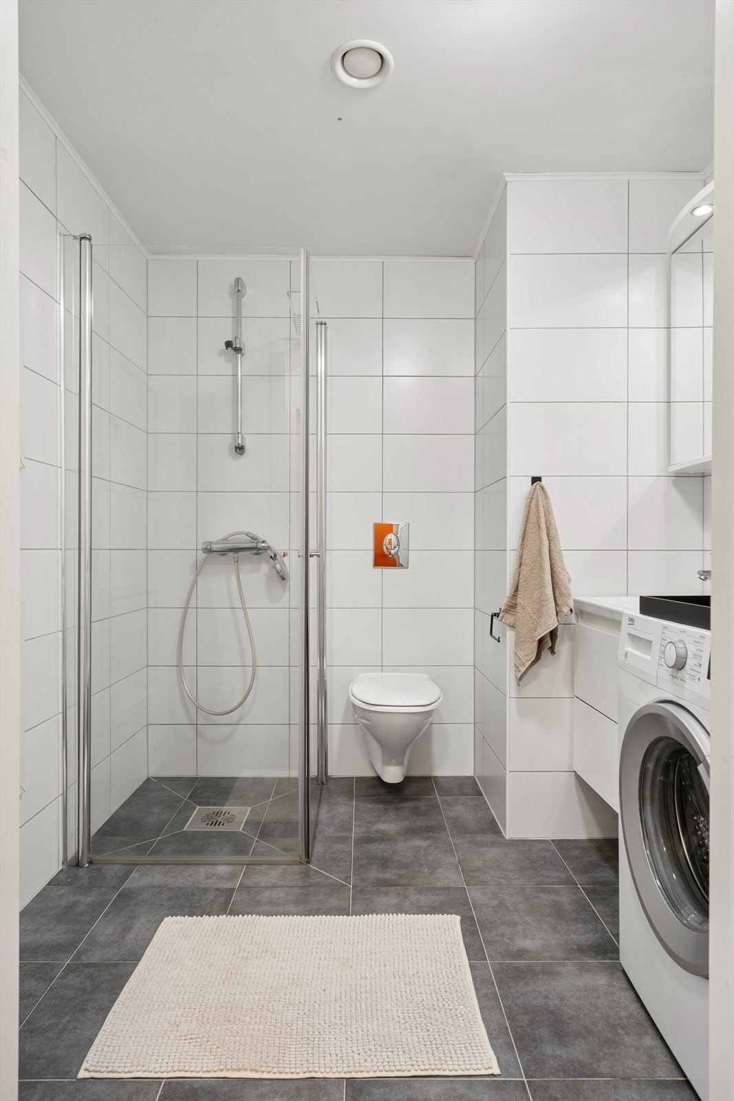 Badet er utstyrt med praktisk dusjhjørne og vegghengt toalett. Galleribilde