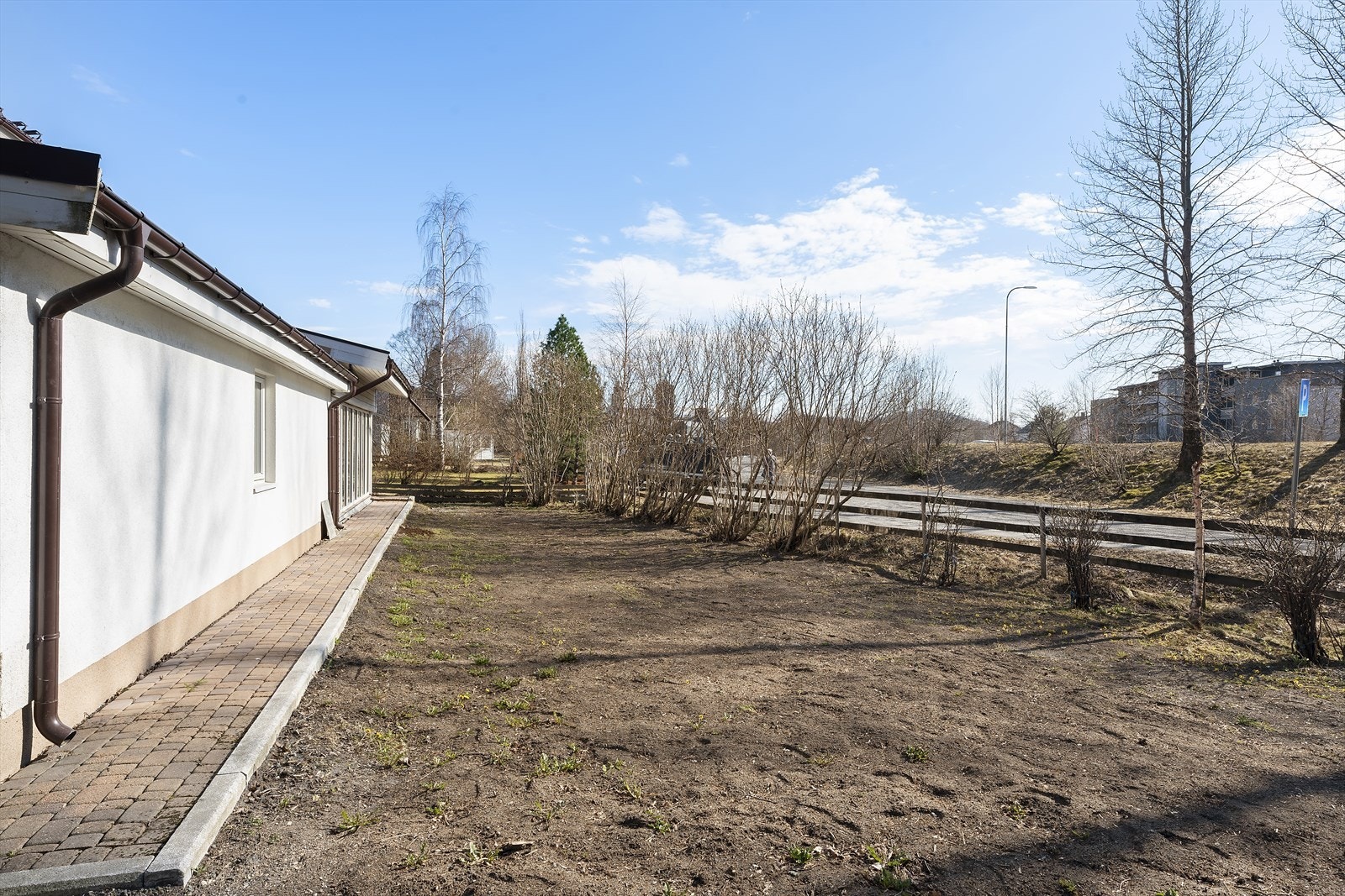 Eiendommen har en relativt flat tomt opparbeidet med plen og brostein. Galleribilde