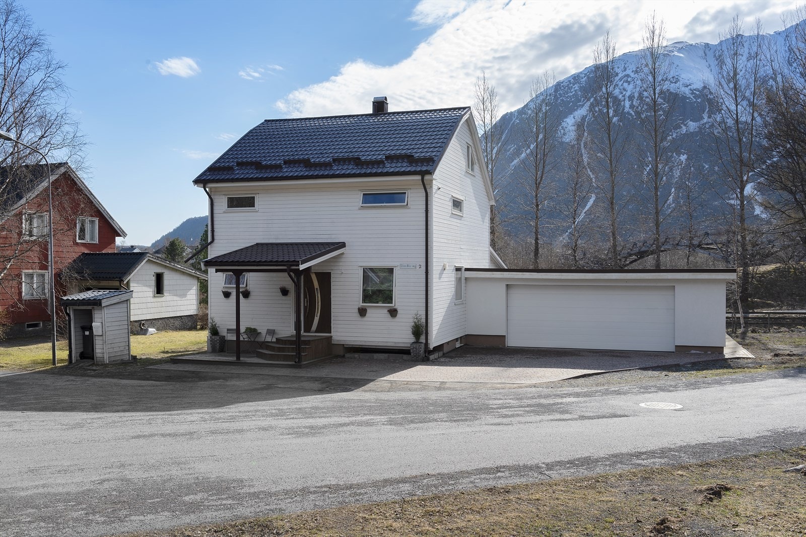 Tomten er opparbeidet med brostein og plen, og har en relativt flat utforming. Galleribilde