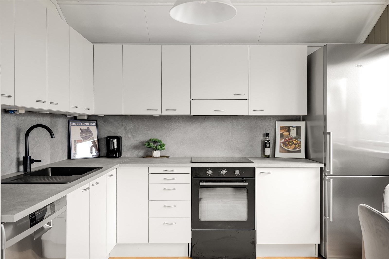 Innredningen består av over-, under og høyskap med laminerte skrog og hvite, glatte fronter. Benkeplate av laminat med nedfelt oppvaskkum. I benkeryggen er det palter i samme stil som benkeplaten. Galleribilde