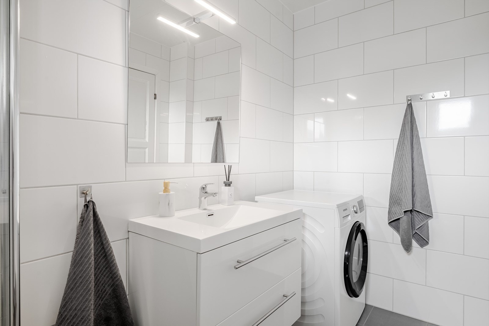 Badet har innredning med skuffer og heldekkende servant med ett-greps blandebatteri. Speil med lys i overkant. Det er opplegg for vaskemaskin. Galleribilde