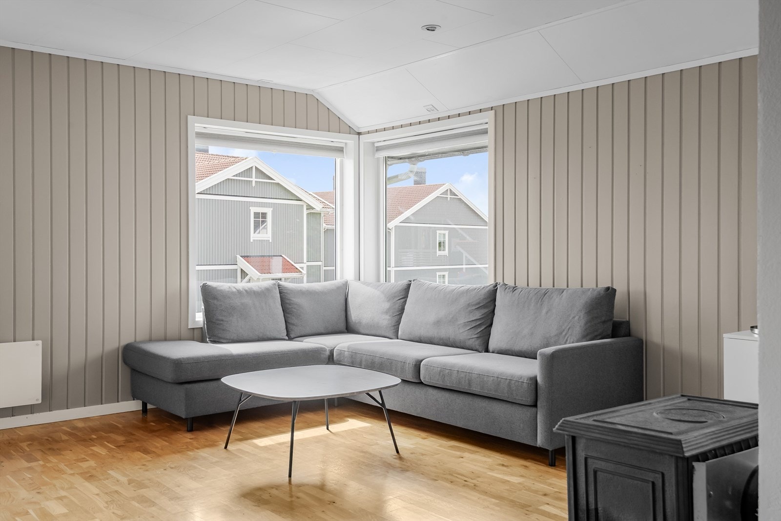 Veggene har panel og er malt i en tidløs gråbeige tone. På gulvet er det parkett. Galleribilde