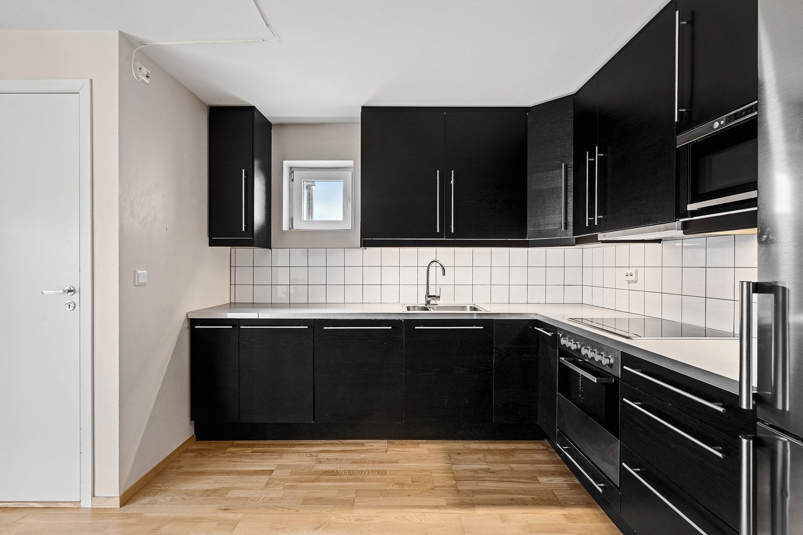 Innredningen har mørke, slette fronter kombinert med lys benkeplate, som gir et moderne uttrykk. Her er det godt med både skap- og benkeplass. Galleribilde