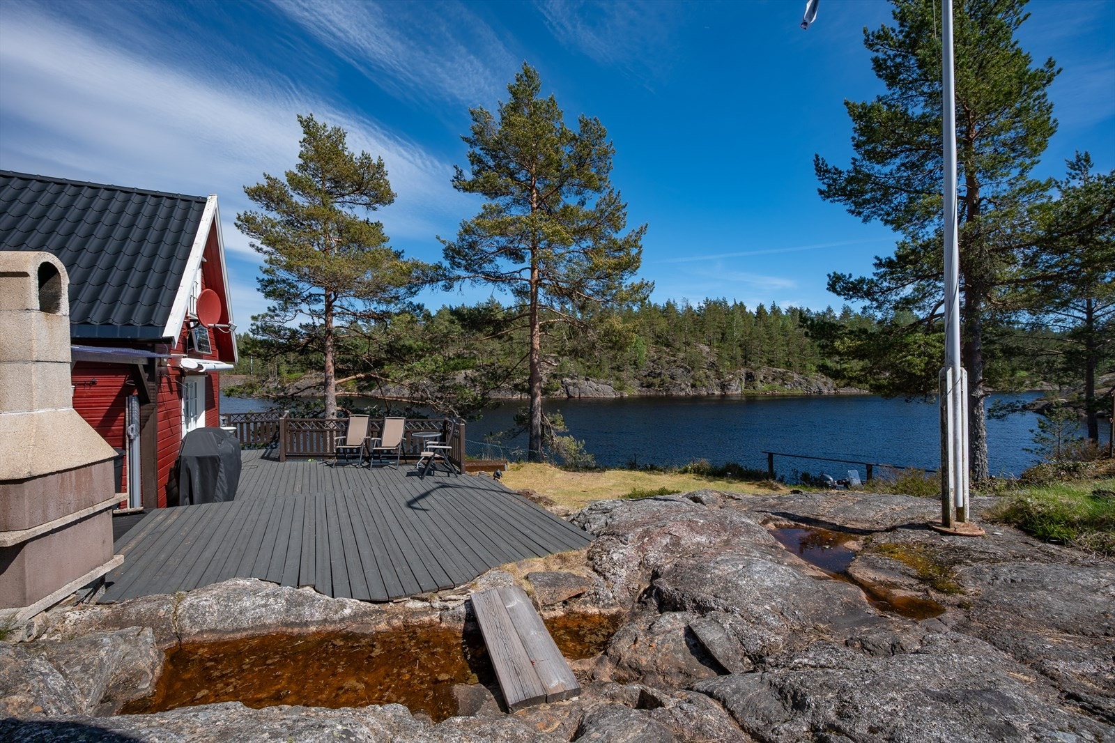 Svaberg, flaggstang og stort solrikt terrasseanlegg Galleribilde