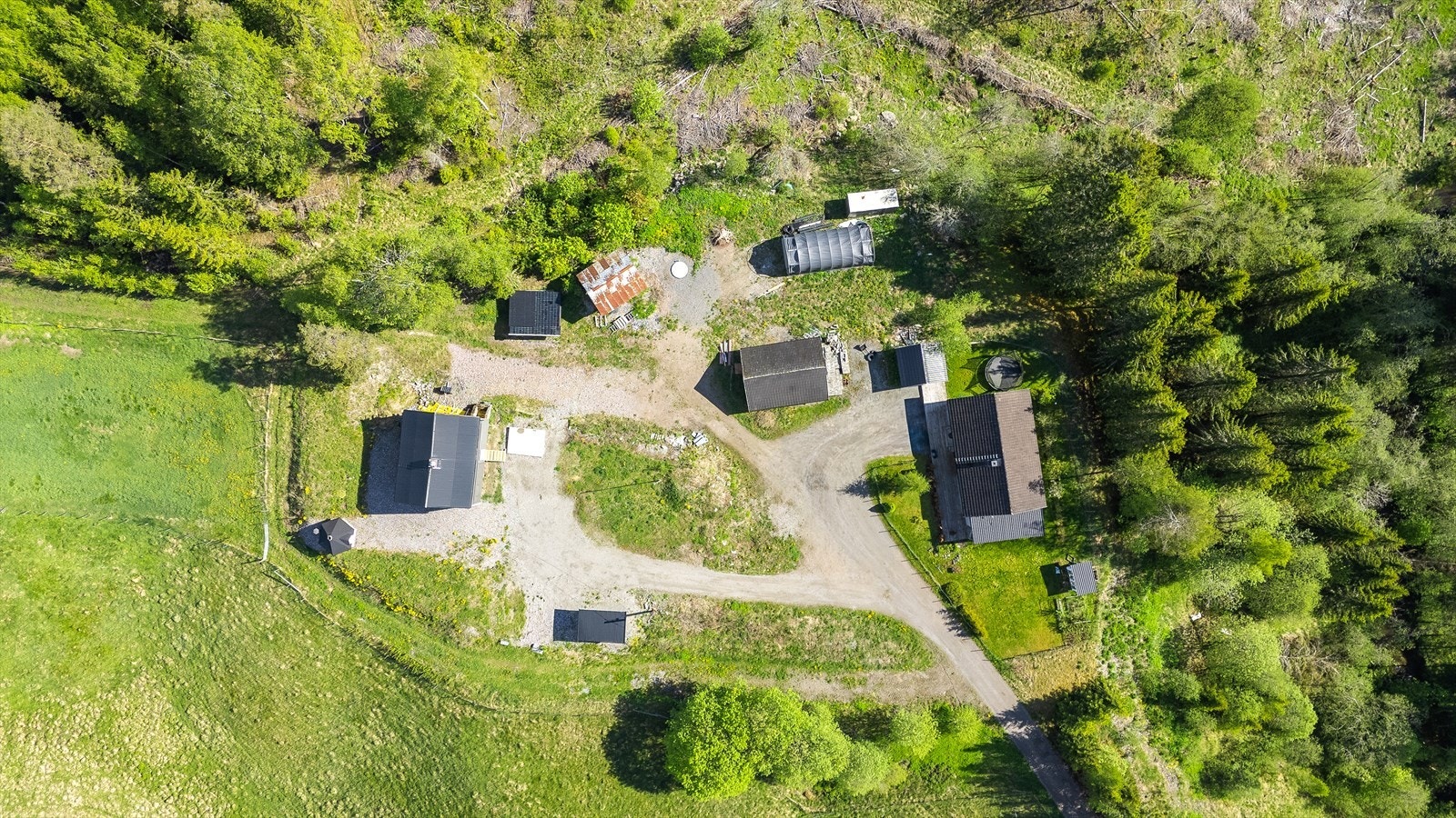 Flyfoto som viser tunet med hovedhus og diverse uthus. Galleribilde
