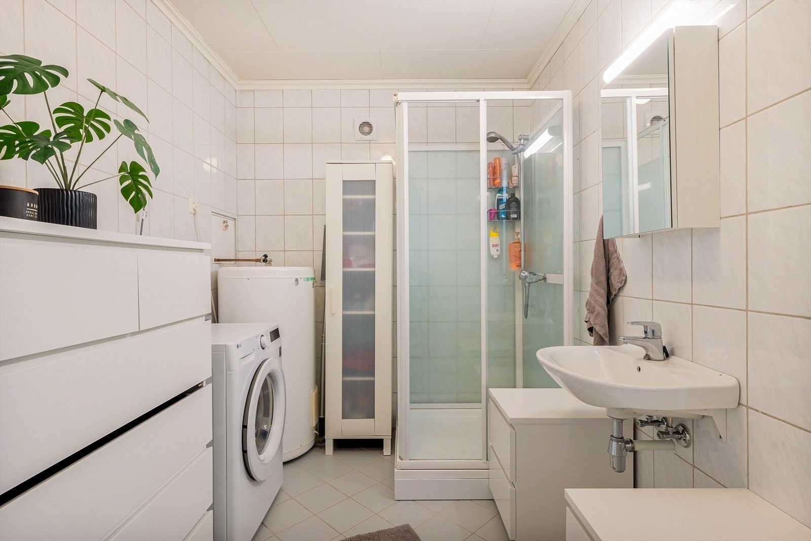 Badet er utstyrt med dusjkabinett, servant, toalett og opplegg for vaskemaskin. Galleribilde