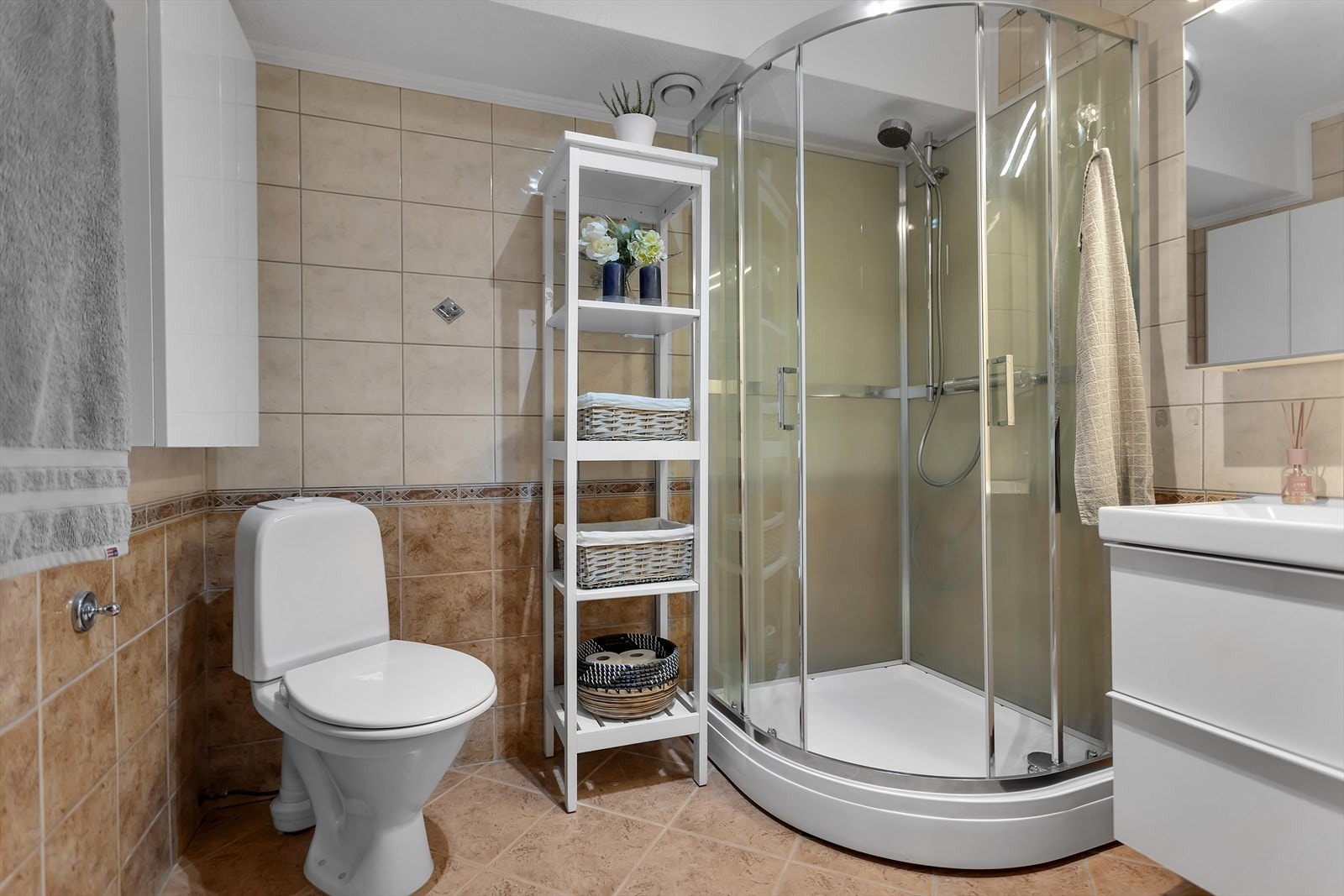 Badet er utstyrt med toalett, dusjkabinett og servantinnredning, og er tilknyttet boligens balanserte ventilasjonsanlegg. Galleribilde