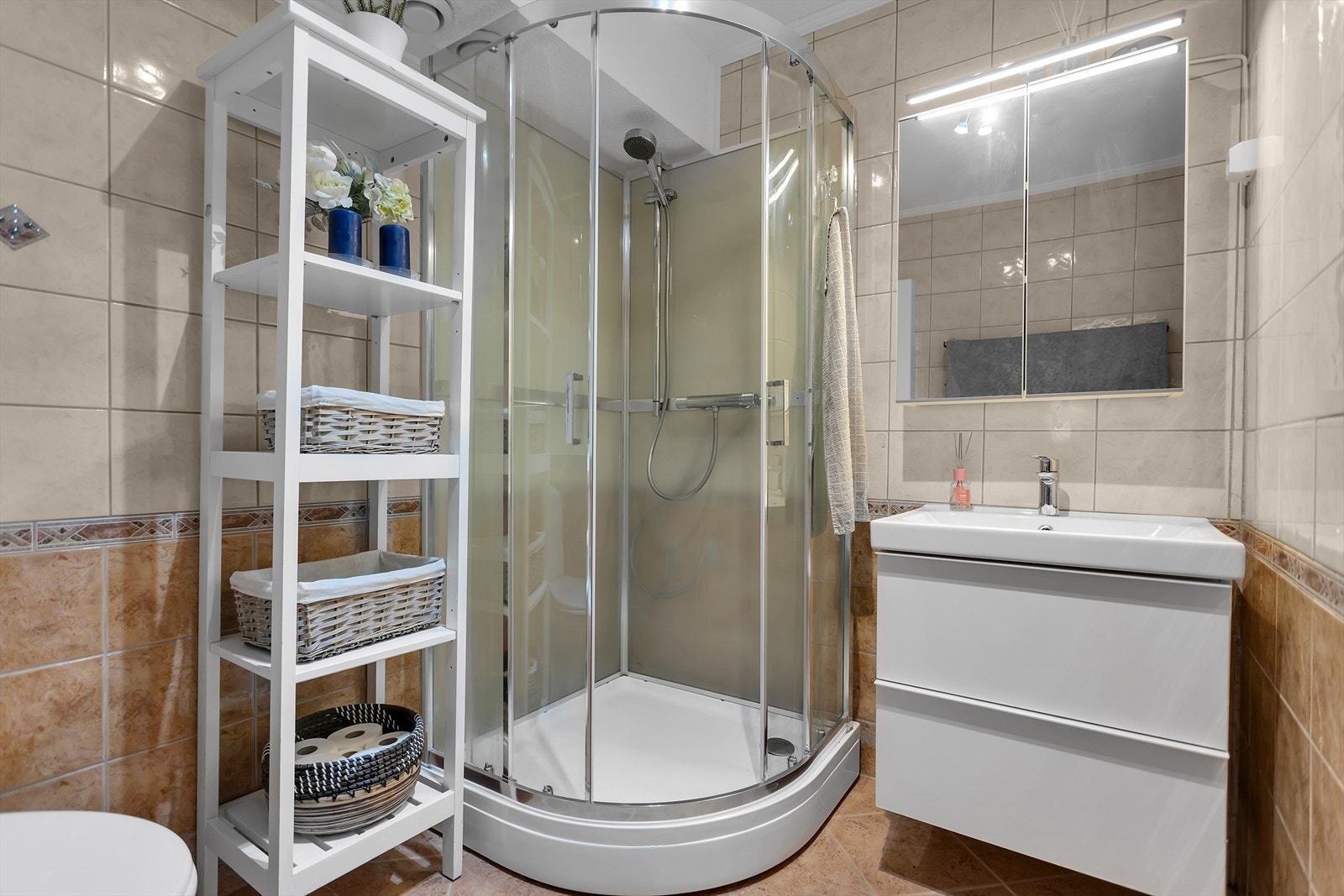 Badet har flislagte overflater, gulvvarme og dusjkabinett. Termostaten til gulvvarmen ble byttet i 2024. Galleribilde