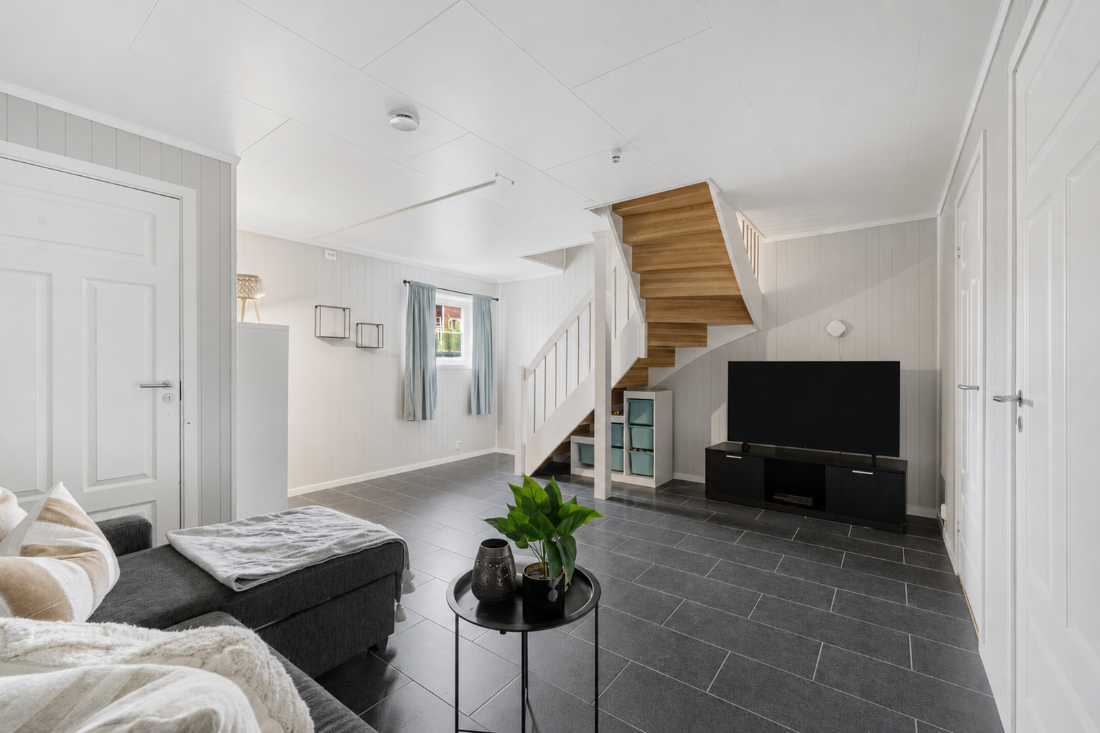 I underetasjen ligger et hyggelig TV-rom som gir familien en ekstra oppholdssone.
Foto: bilde er redigert med KI og avvik kan forekomme. Galleribilde