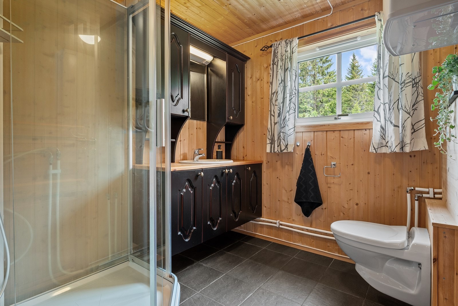 Badet på hytten er utstyrt med veggmontert wc, dusjhjørne, godt med benke -og skapplass. Galleribilde