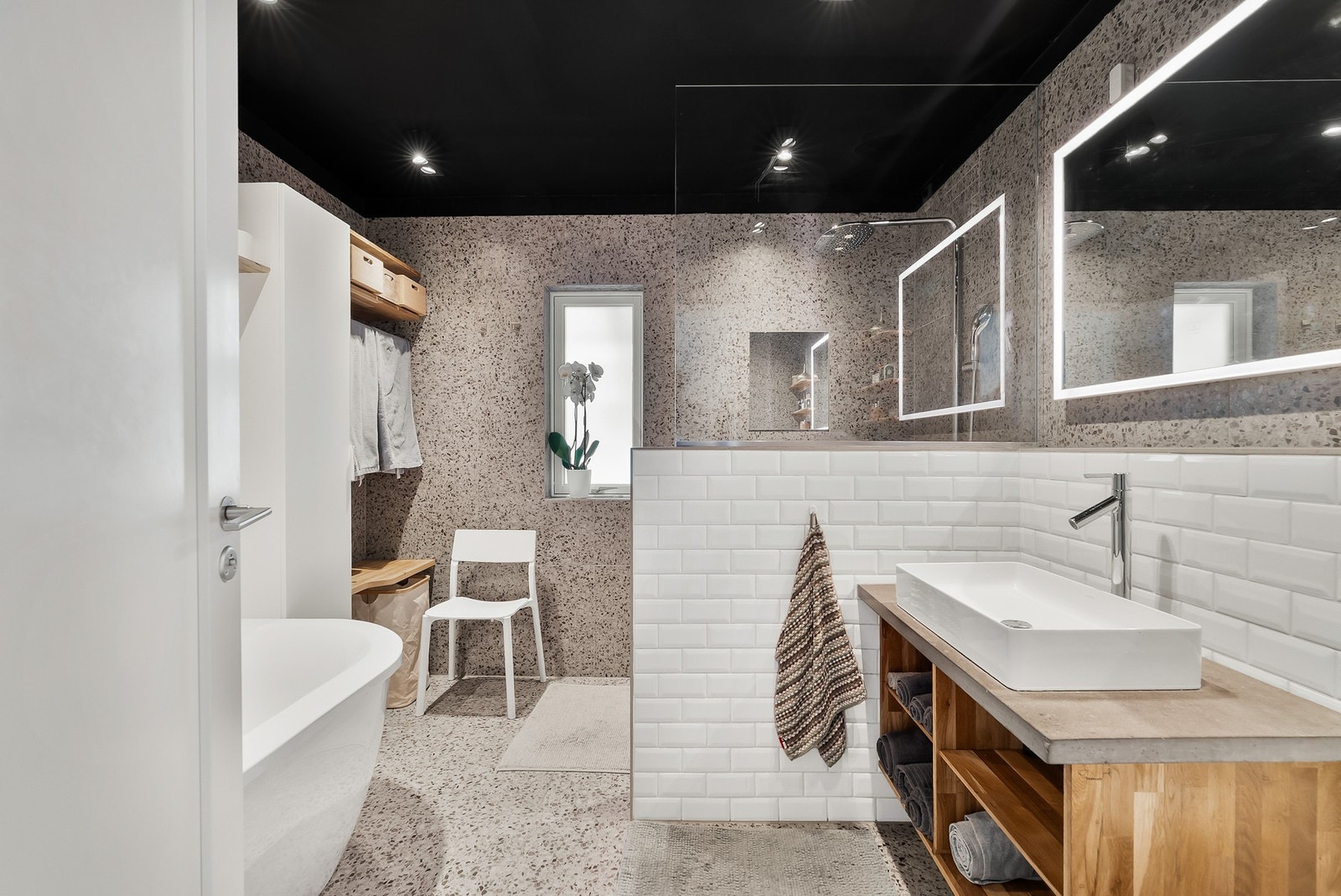 Boligens hoveddel byr på et lekkert bad med moderne materialvalg og en praktisk servantinnredning. Galleribilde