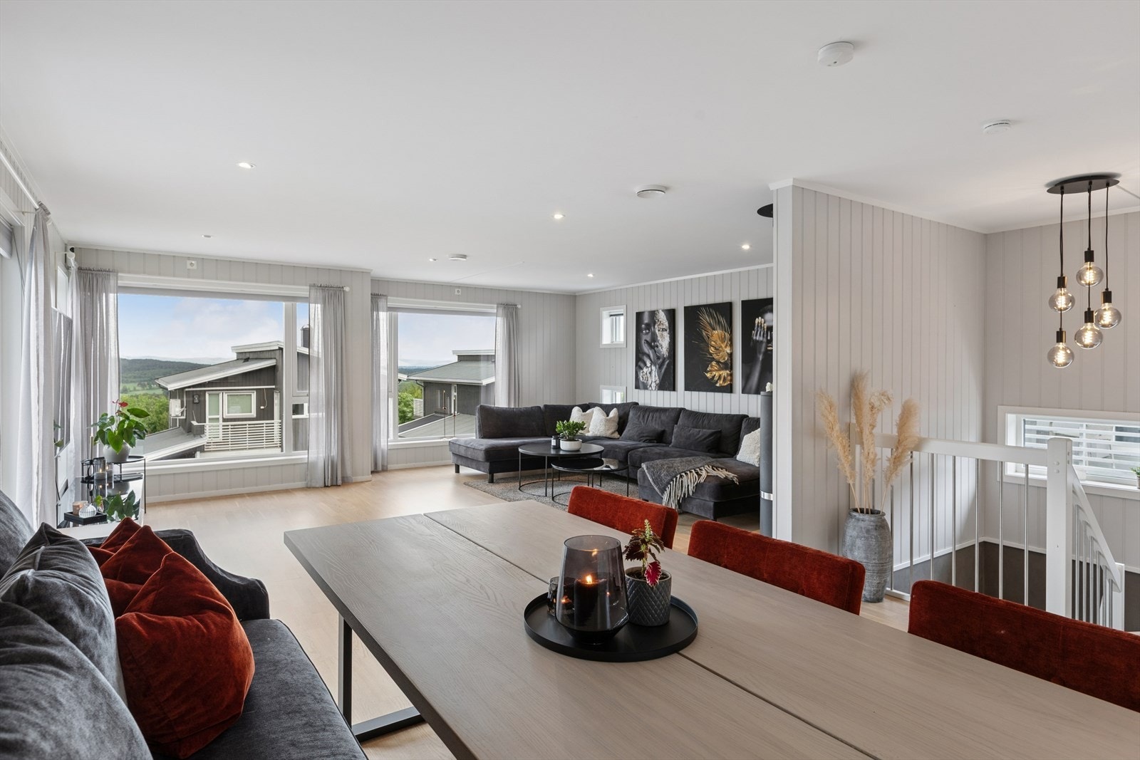 Den åpne løsningen mellom stue, spisestue og kjøkken skaper en sosial og moderne atmosfære med naturlige soner for både hverdag og selskap. Galleribilde