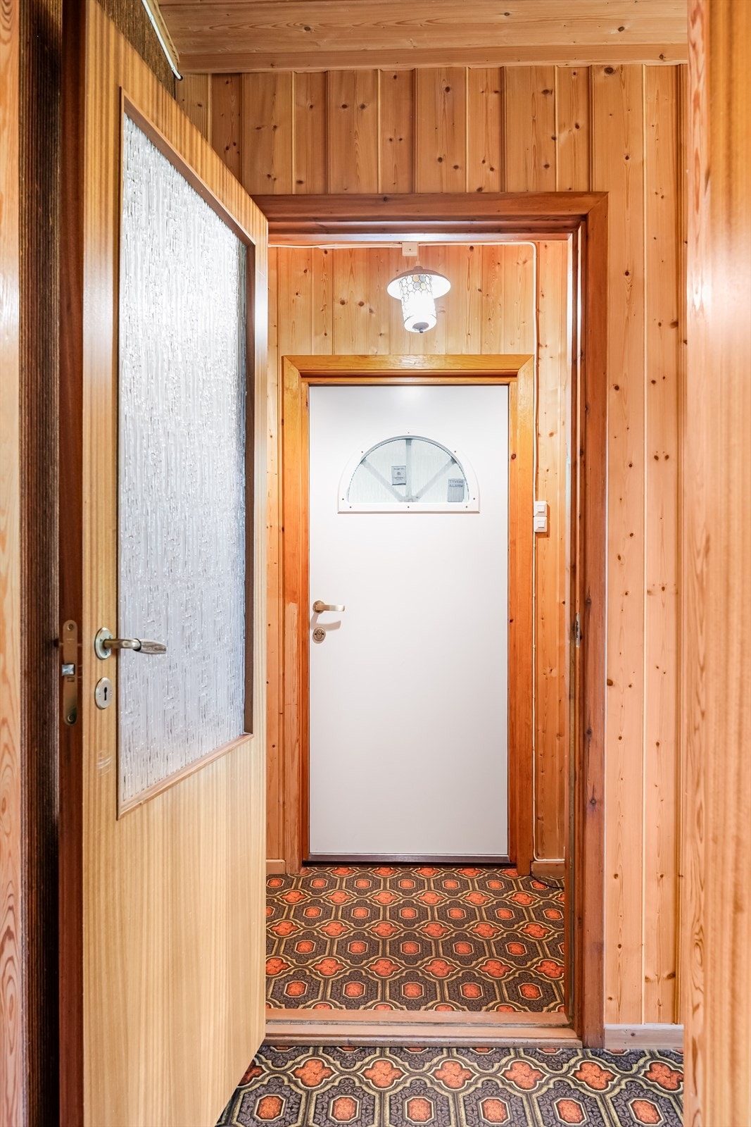 Inne møtes du av entré og gang med gulvbelegg og panelvegger. Galleribilde