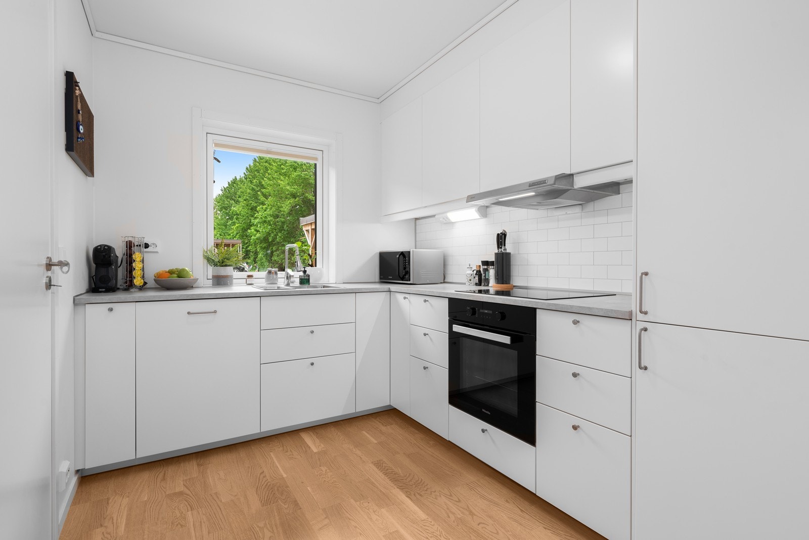 Innredningen har hvite, glatte fronter og laminatbenkeplate. Galleribilde