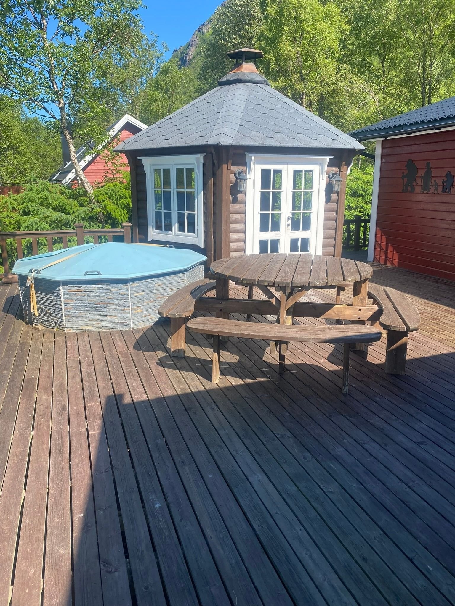Del av veranda med stor benk, vedfyrt badestamp (med ekstra isolering) og grillhytte for trivelige kvelder. Galleribilde