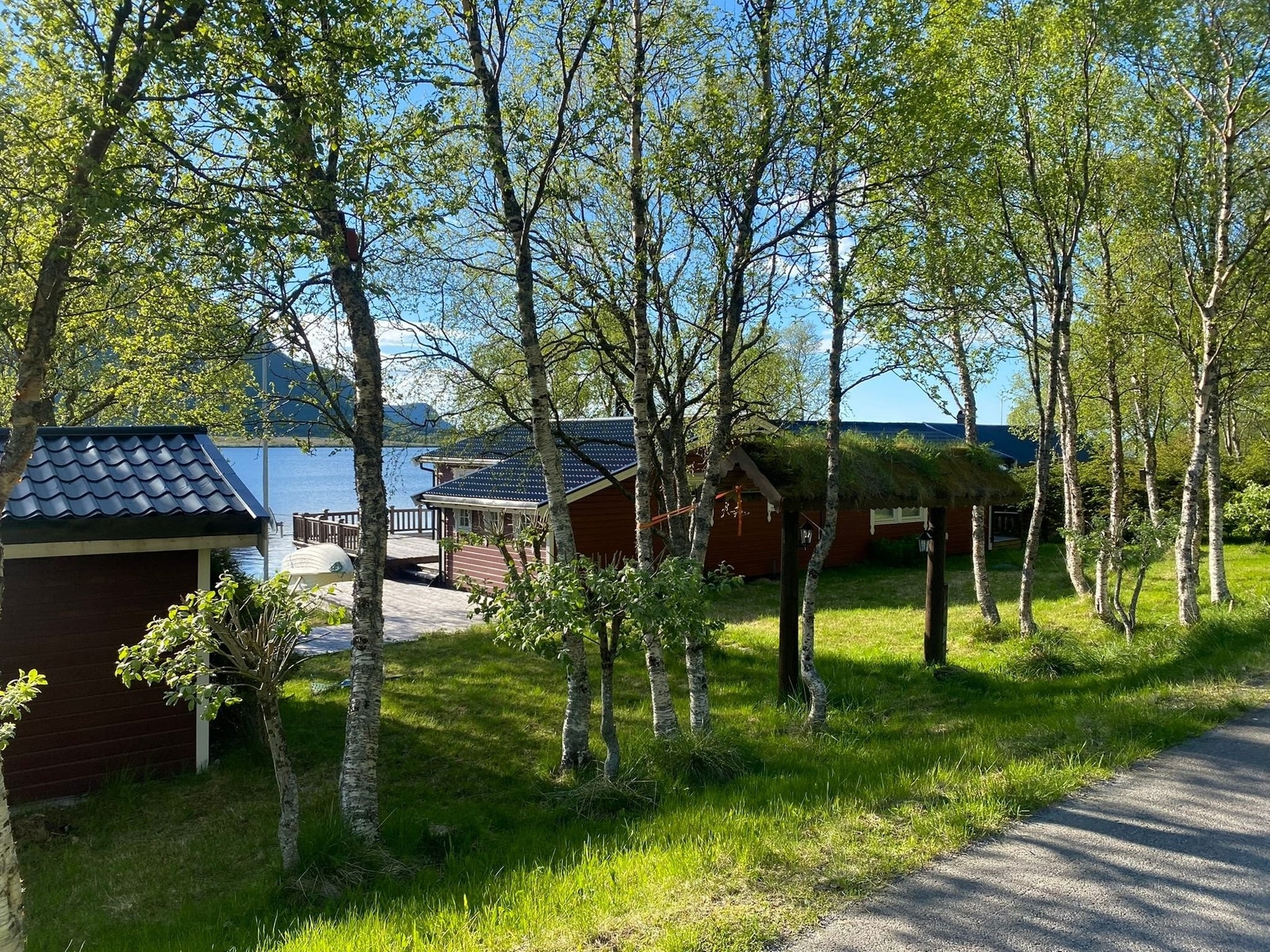 Hytten sett fra vei ned mot vannet. Redskapsbod til venstre i bildet. Galleribilde