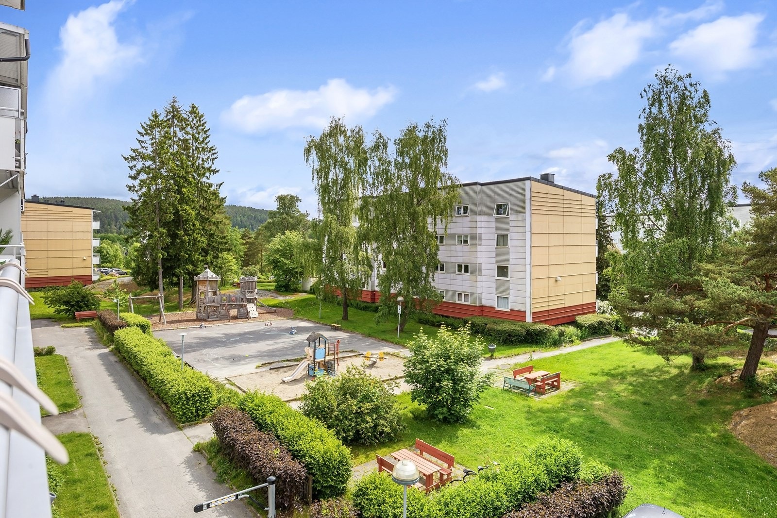 Koselig fellesareal med lekeplass og benker. Galleribilde