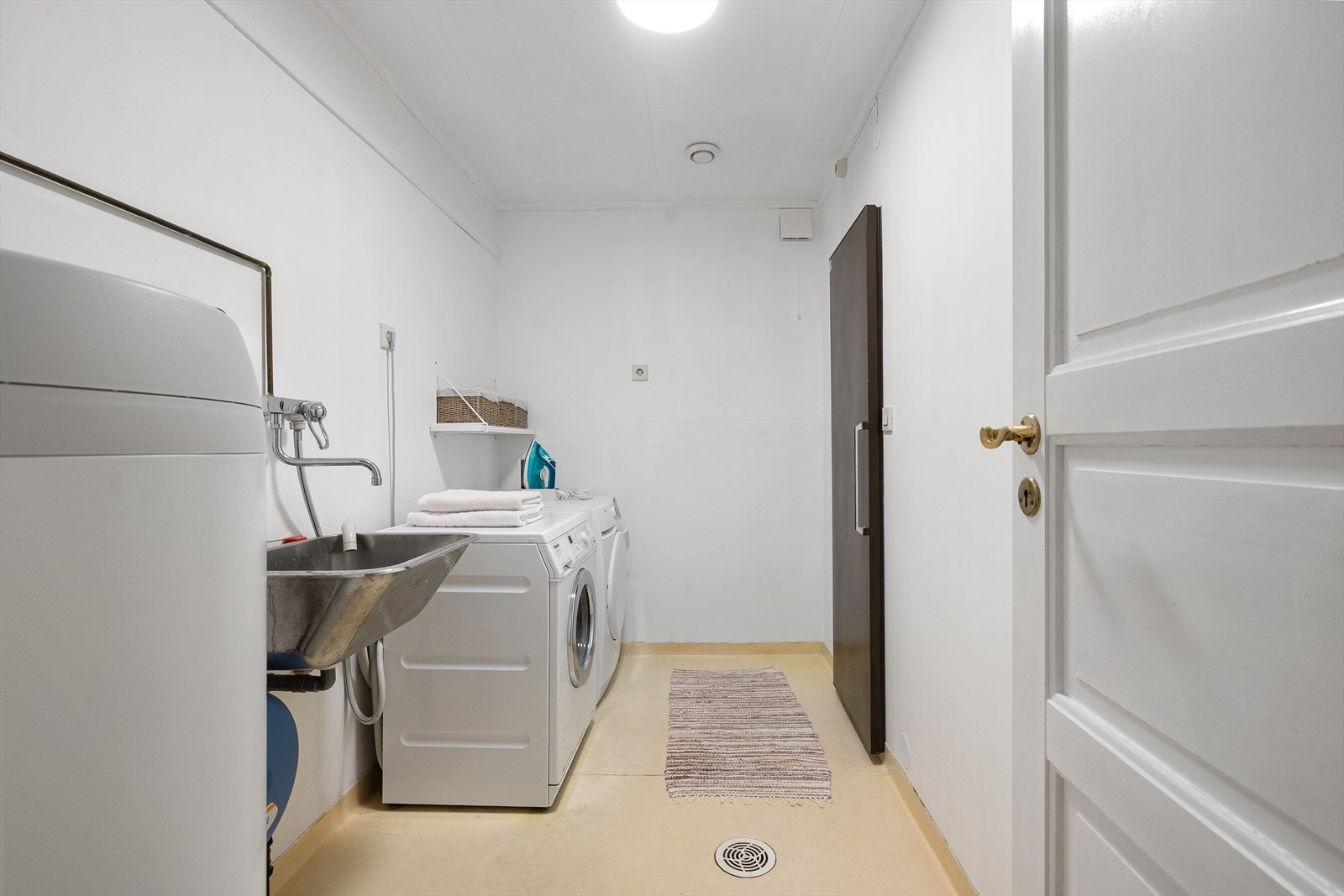 Praktisk, separat vaskerom med sluk i gulvet, skyllekar og opplegg for vaskemaskin og tørketrommel. Galleribilde