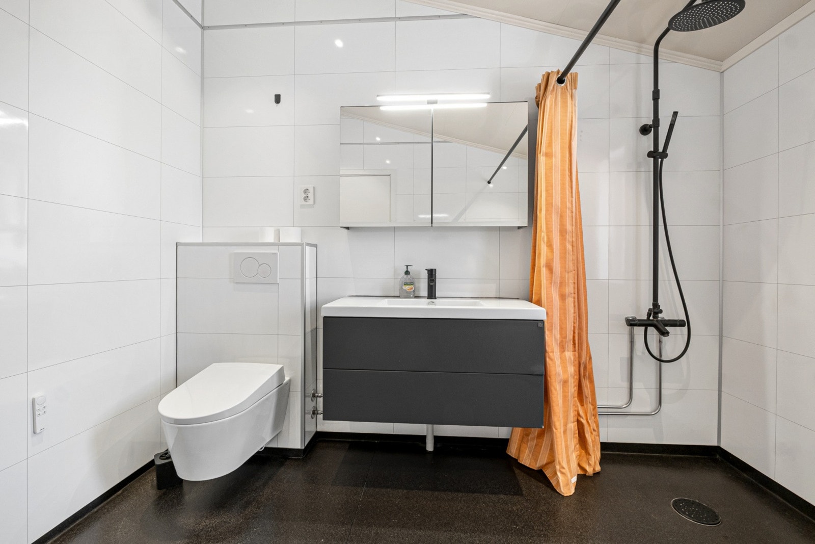 Badet har vegghengt toalett, innredning med nedfelt servant og dusj. Galleribilde