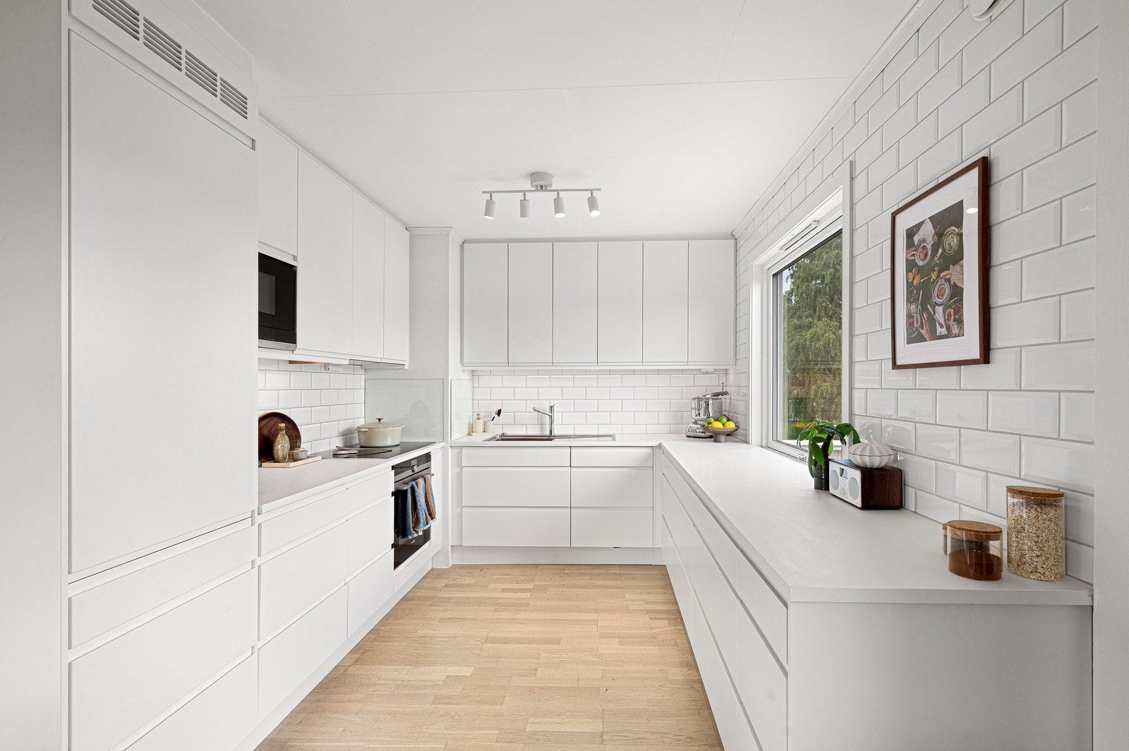 Stort og fint kjøkken på 8,6 m². Hvit, stilren innredning med integrerte hvitevarer. Galleribilde