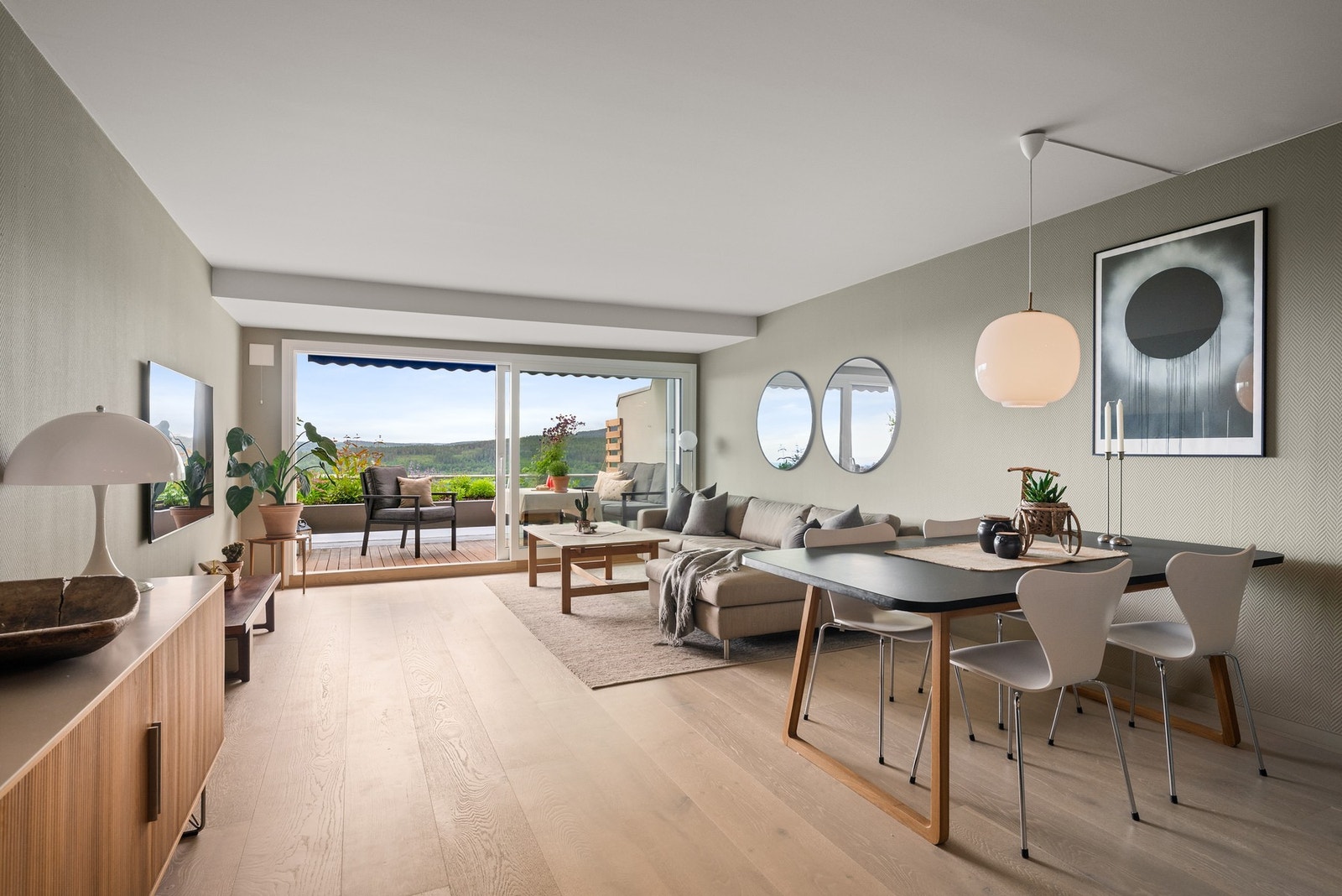 Den romslige stuen gir mange møbleringsmuligheter og har en fin balanse mellom sosial sone, spiseplass og direkte adkomst til terrassen. Galleribilde