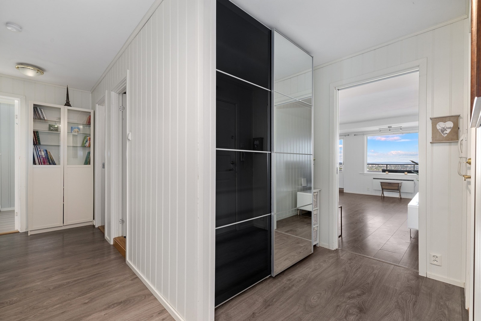 Entréen har en romslig skyvedørsgarderobe med speilfront Galleribilde