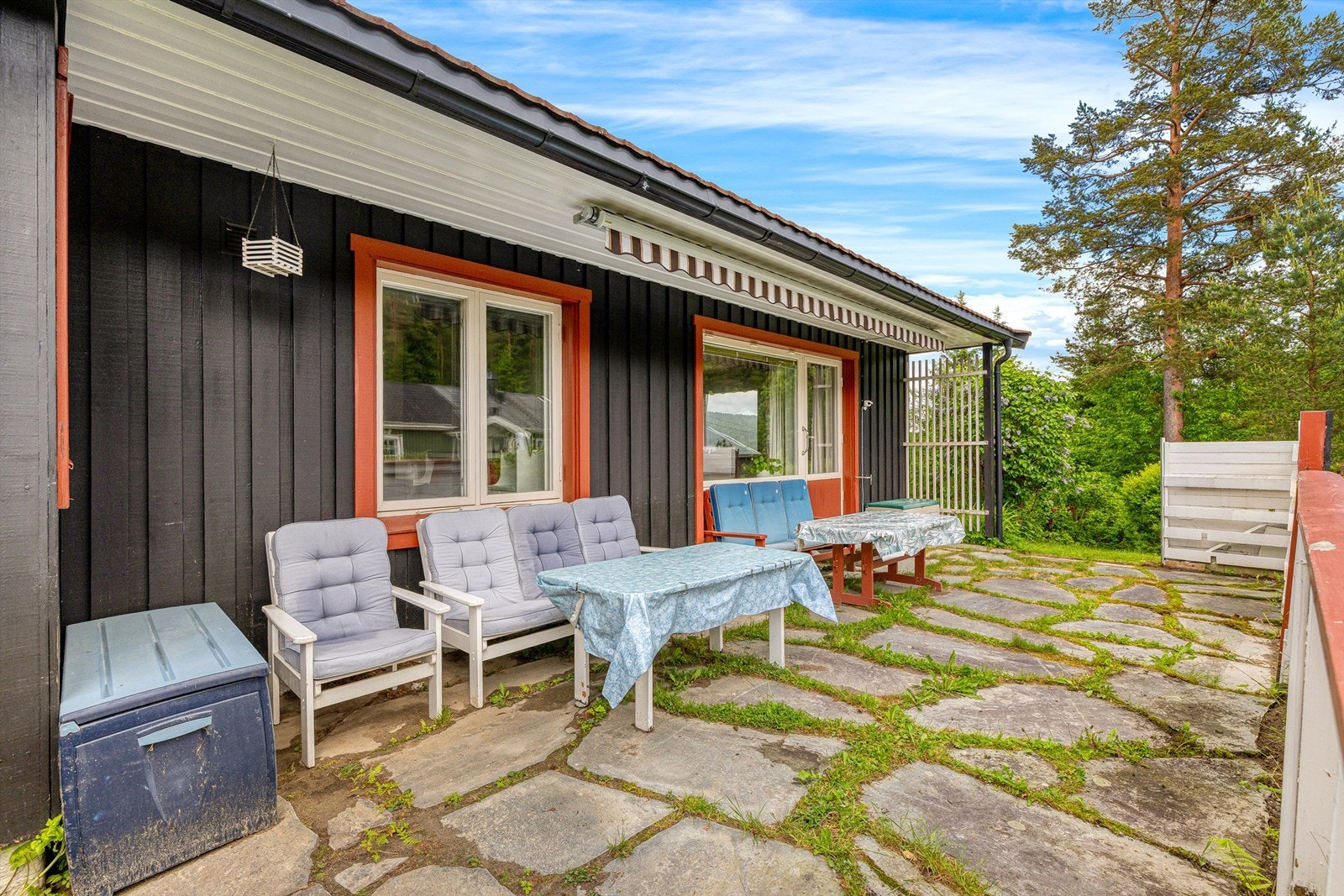 Hyggelig markterrasse med utgang fra boligens stue, terrassemarkise montert for praktisk solskjerming på solfylte varme dager Galleribilde