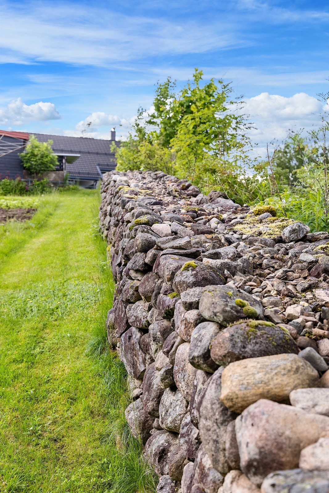 Langs eiendommens grense er det bygget en flott steingjerde i naturstein som er stablet Galleribilde