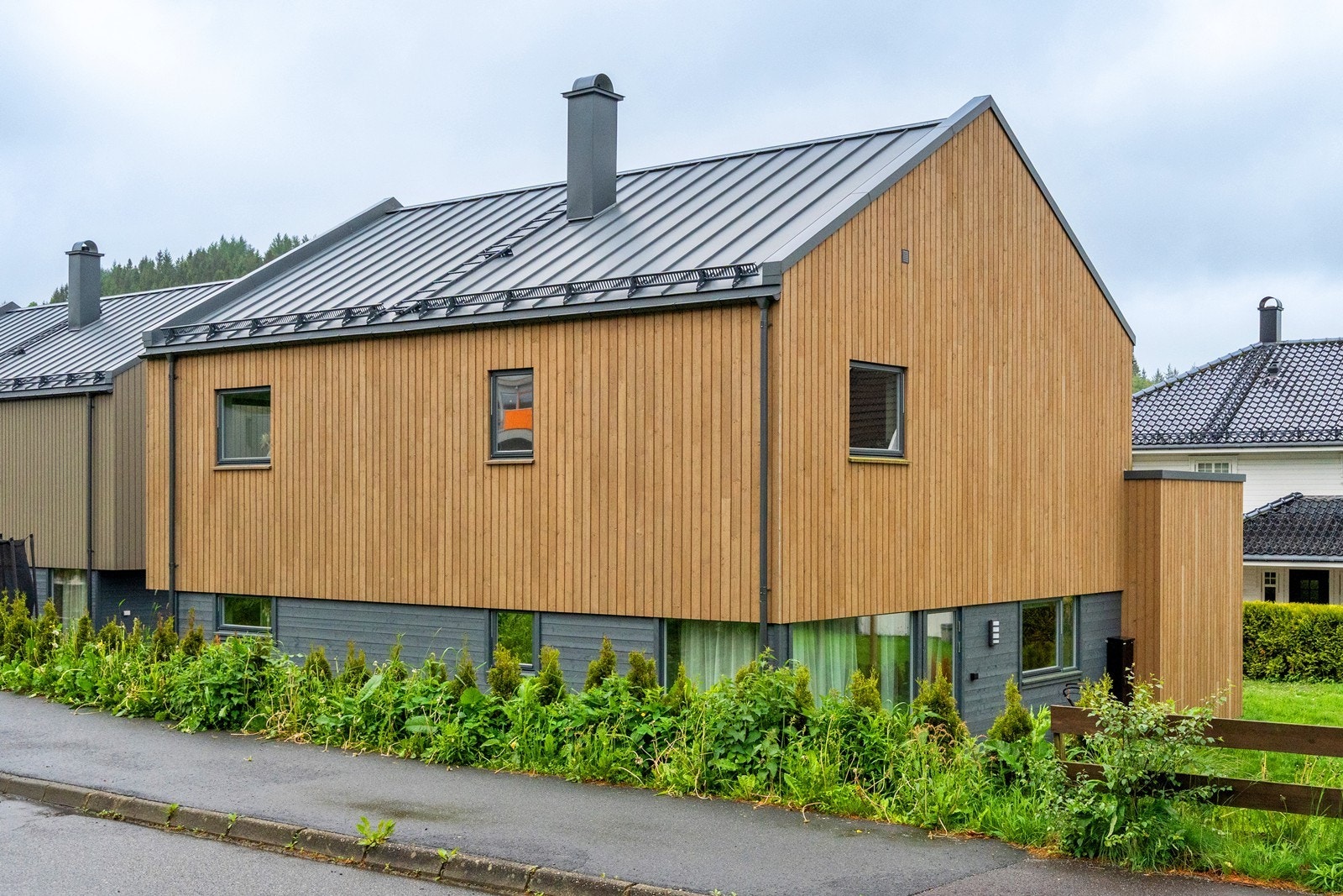 Eiendommen har en stor og grønn plen og det er plantet hekk rundt deler av eiendommen. Galleribilde