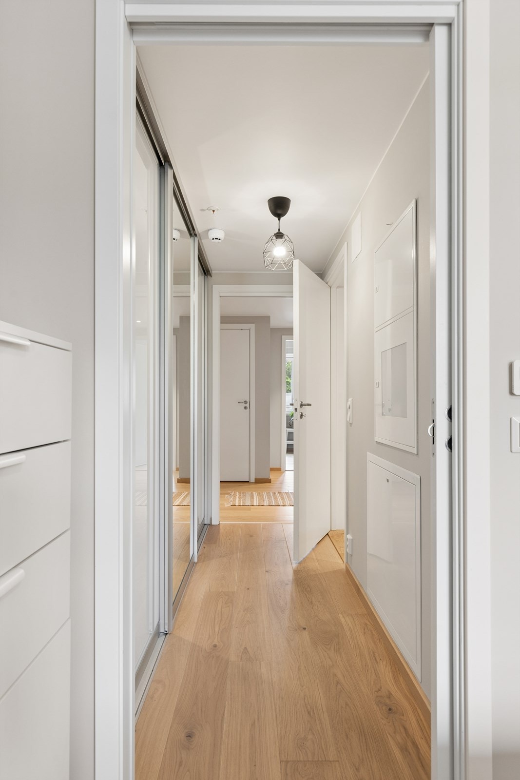 Praktisk mellomgang/omkledningsrom med stor skyvedørsgarderobe på den ene siden. Galleribilde