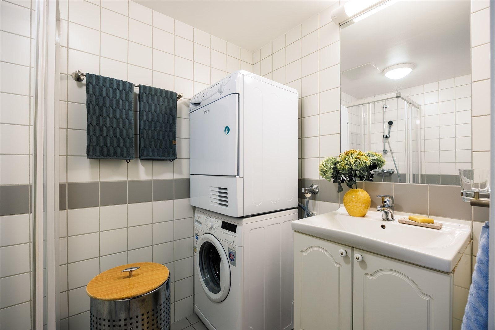 Praktisk baderomsinnredning med innfelt speil, samt opplegg for vaskemaskin og tørketrommel. Galleribilde