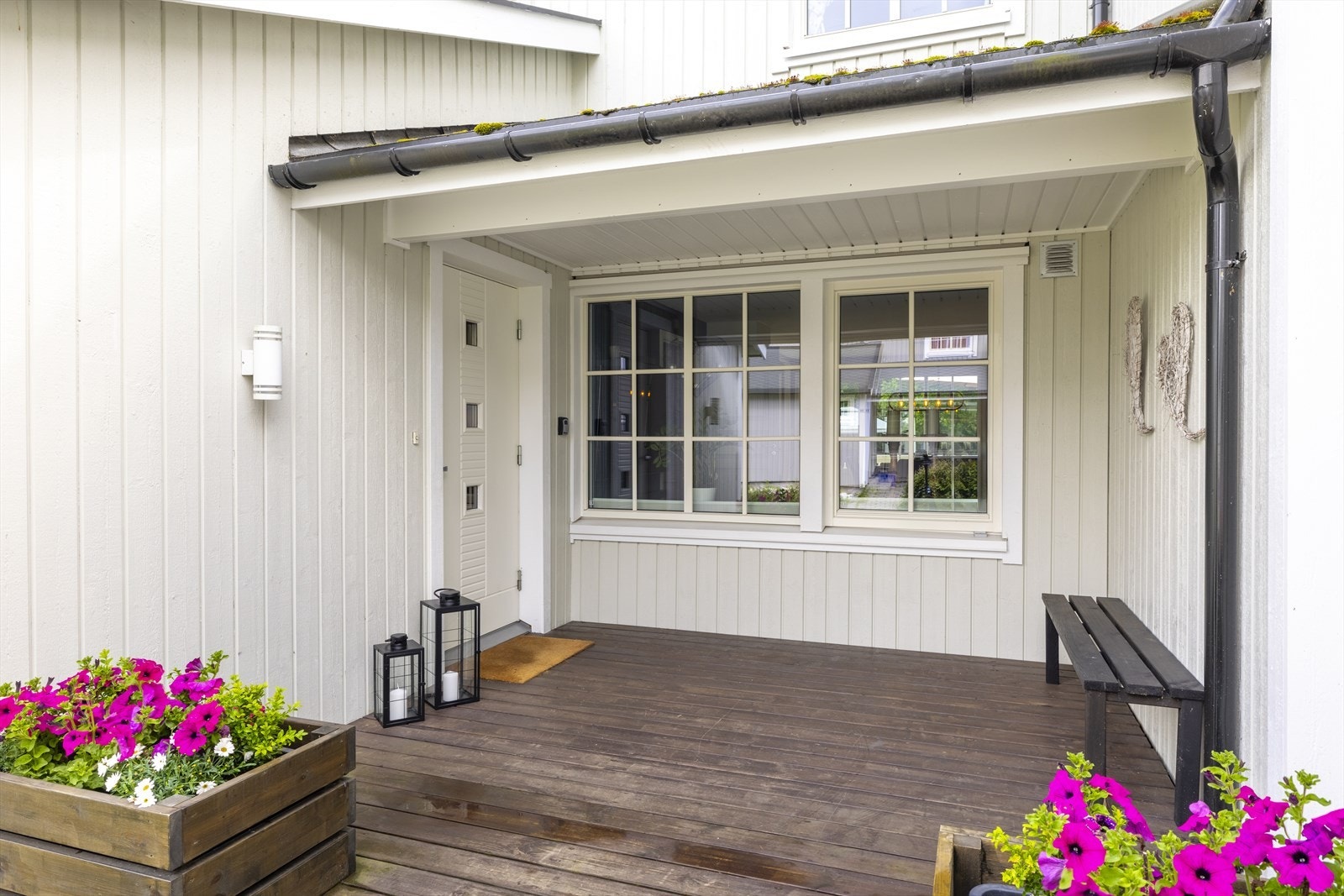 Overbygget inngangsparti med plass til en liten sittebenk. Galleribilde