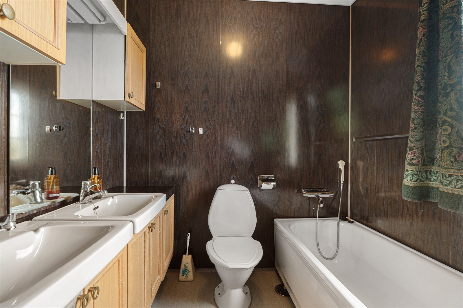 Badet er utstyrt med dobbel servant, gulvmontert toalett, badekar og dusjkabinett. Galleribilde