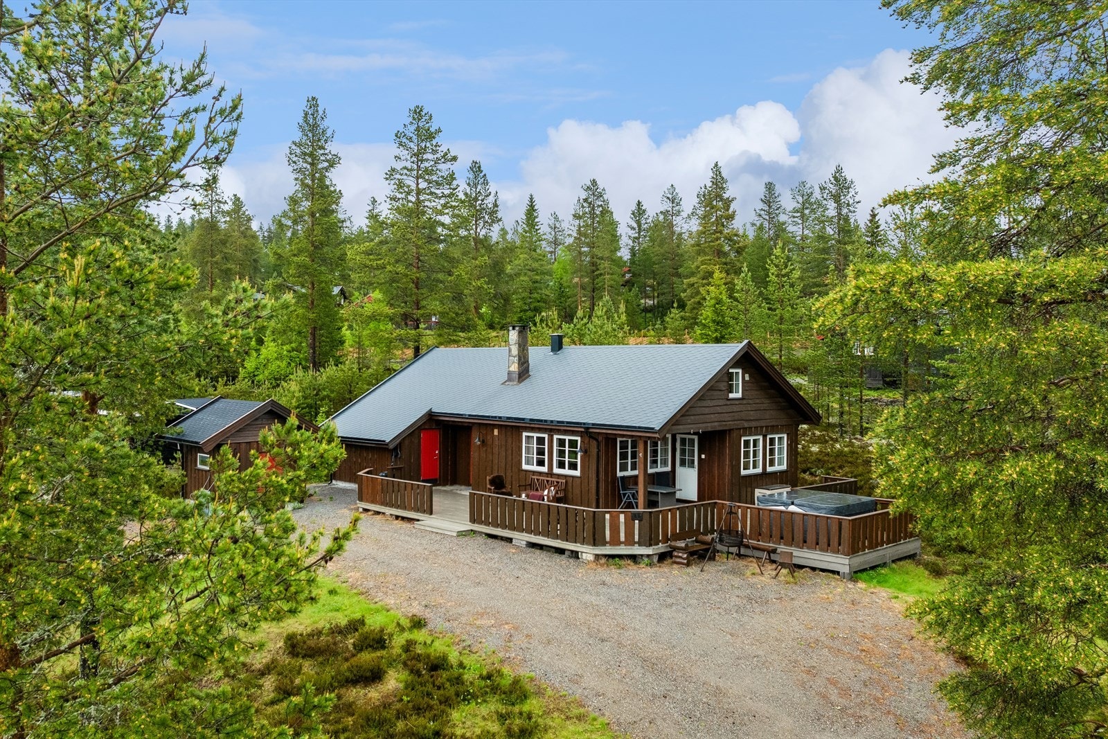 Fritidsbolig fra 2010 med stående, ukantet kledning og to praktiske boder for oppbevaring av ski og utstyr. Galleribilde