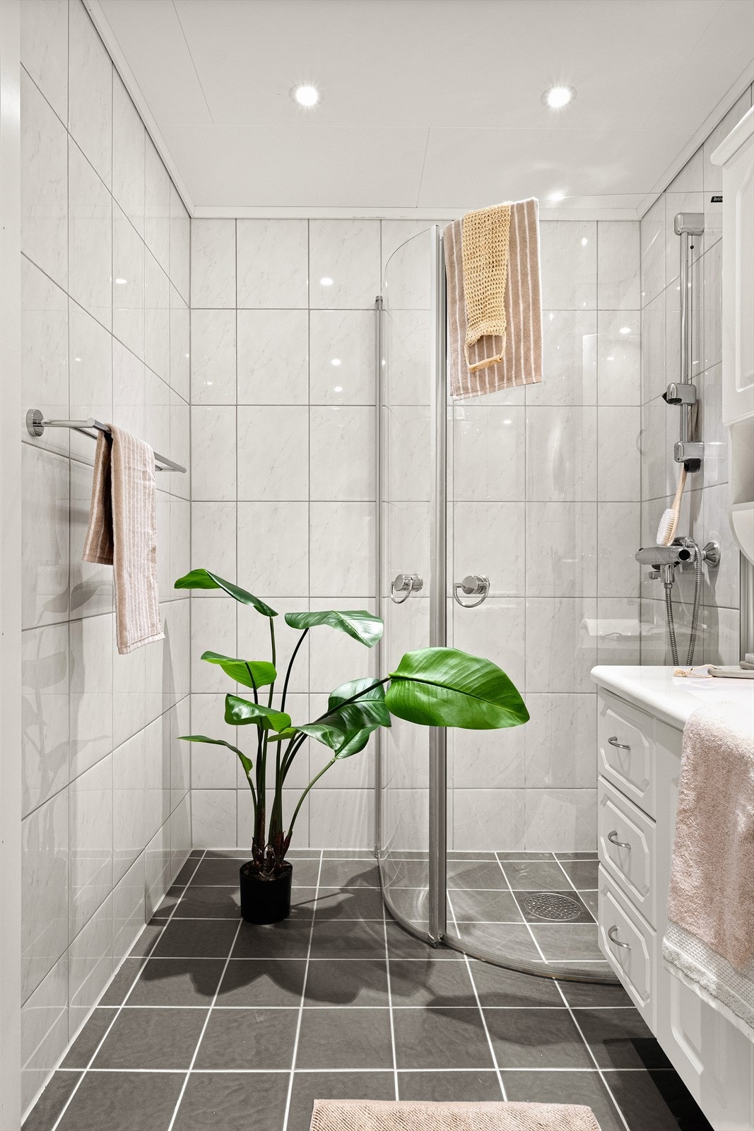 Badet har et areal på 4,0 m², og er innredet med dusjhjørne, benkeskap med nedfelt servant, speil med belysning over, samt varmekabler i gulv. Galleribilde