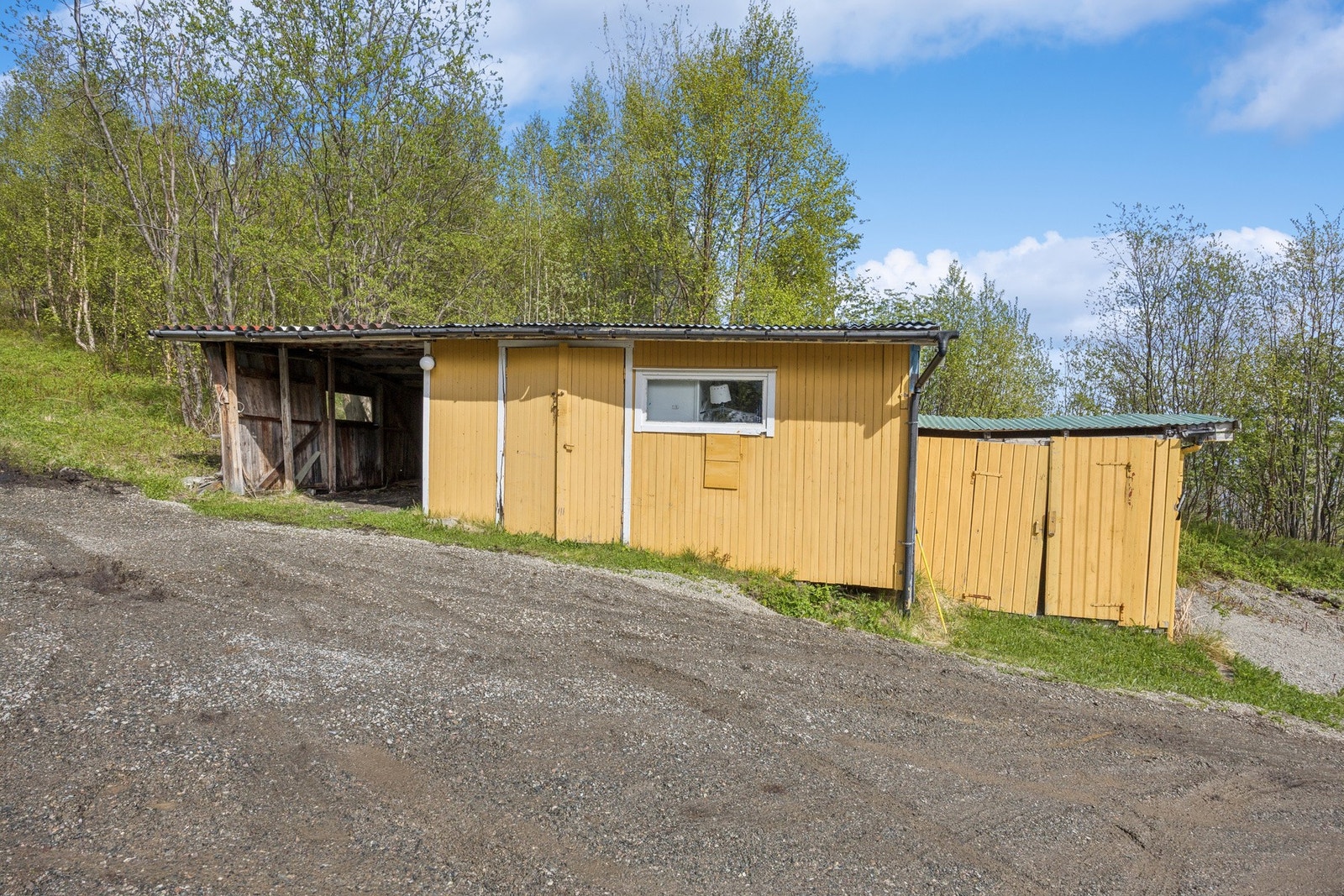 På eiendommen står et uthus med carport og boder for rikelig med lagringsplass. Galleribilde