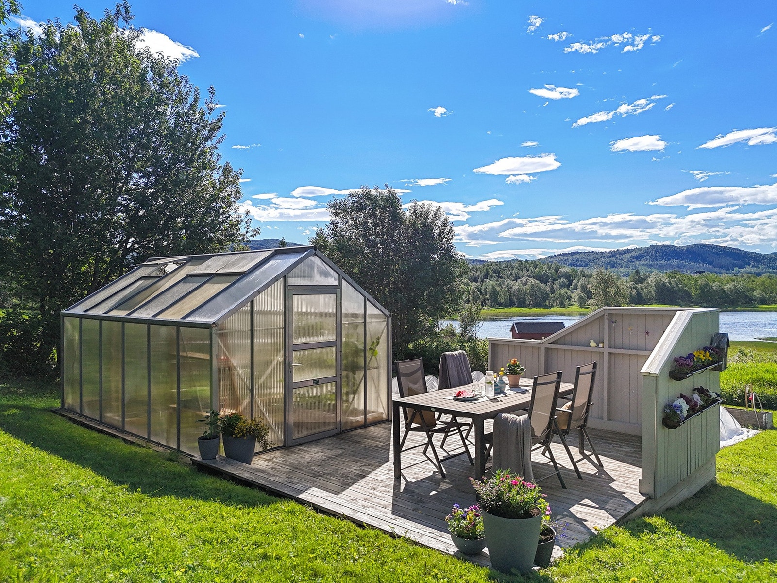 Med tomt på ca. 1,5 mål er du stor og fin hage med drivhus, terrasse med tilgang til vann og god beplantning Galleribilde