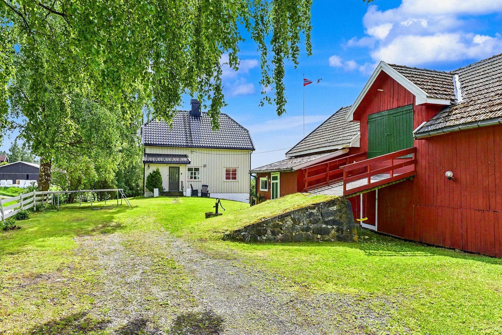 Gruslagt gårdsplass og store grøntarealer. Galleribilde