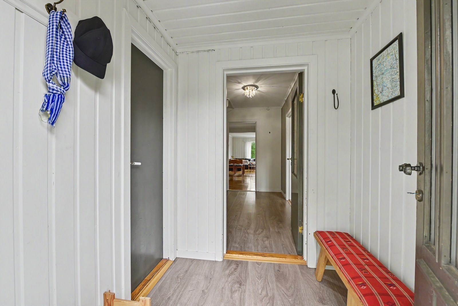 Inngangspartiet har panel på veggene og leder videre inn i boligens fellesrom. Galleribilde